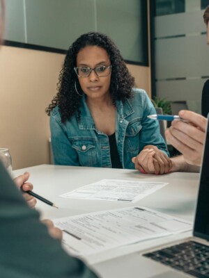 A couple reviewing documents with a professional in an office setting, focusing on financial planning.