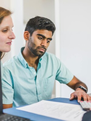 A young couple in discussion with a real estate agent in a modern office setting.