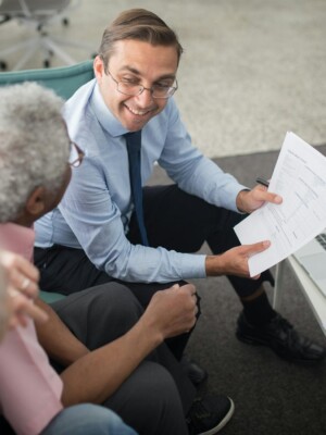 Financial advisor discussing documents with senior clients in an office setting, showcasing a collaborative consulting session.
