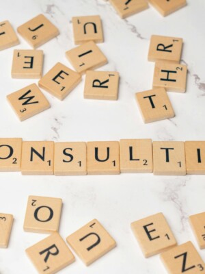 Scrabble tiles spelling 'Consulting' on a stylish marble surface symbolize strategic creativity.
